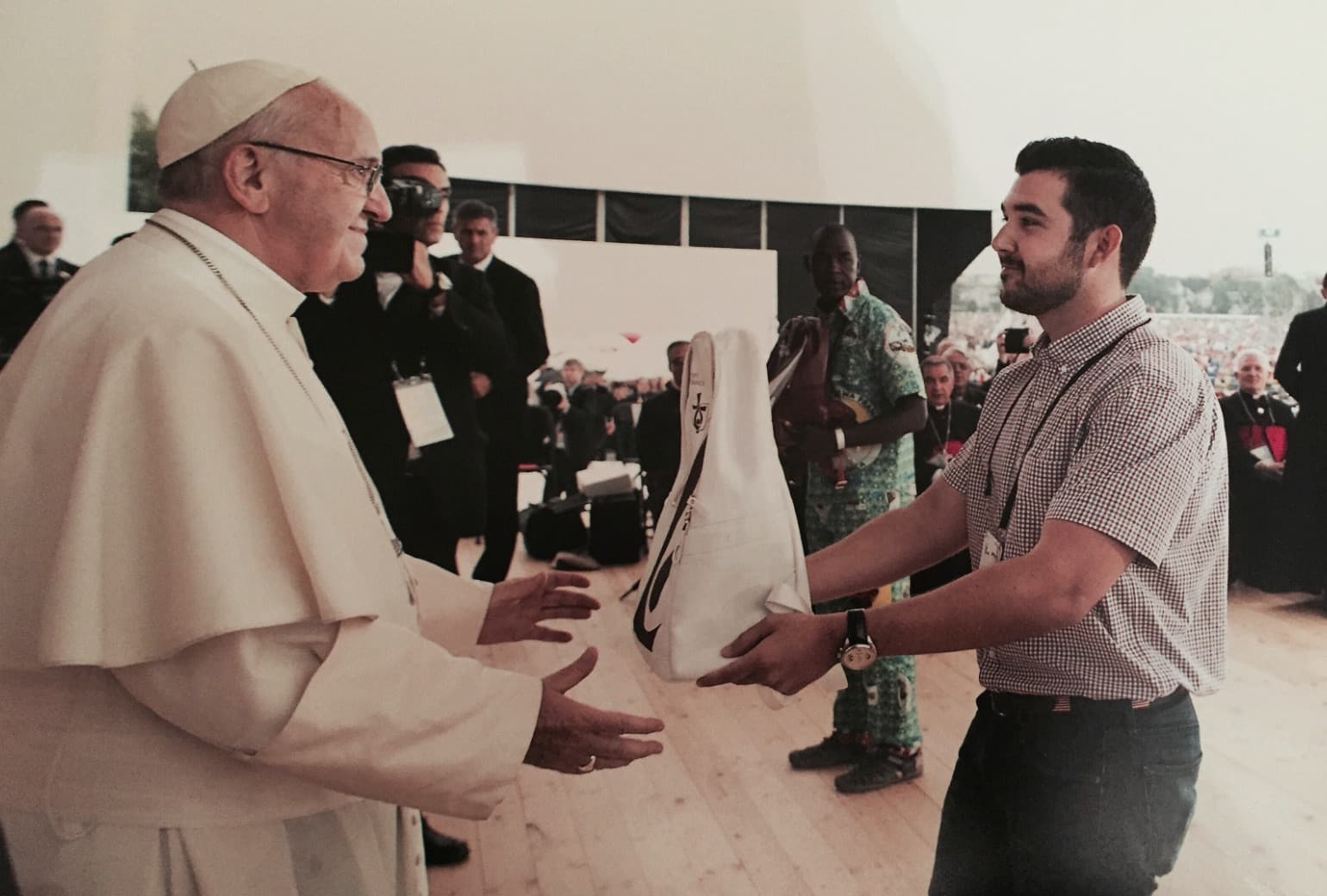 ActivateSwag founder Patrick Lowenthal handing Pope Francis a custom-designed pilgrim backpack on stage at World Youth Day 2016 in Krakow, Poland.